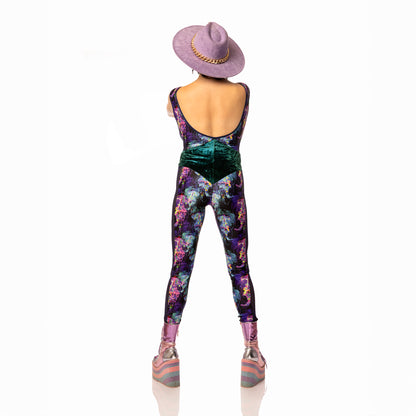 Jellyfish Catsuit, a handmade-to-order piece in purple, black, pink and green tropical jellyfish  printed spandex. This low back catsuit is both stylish and sustainable. The v-neck design features a flattering teal, foiled velvet waist panel and black mesh front insert and side panels.