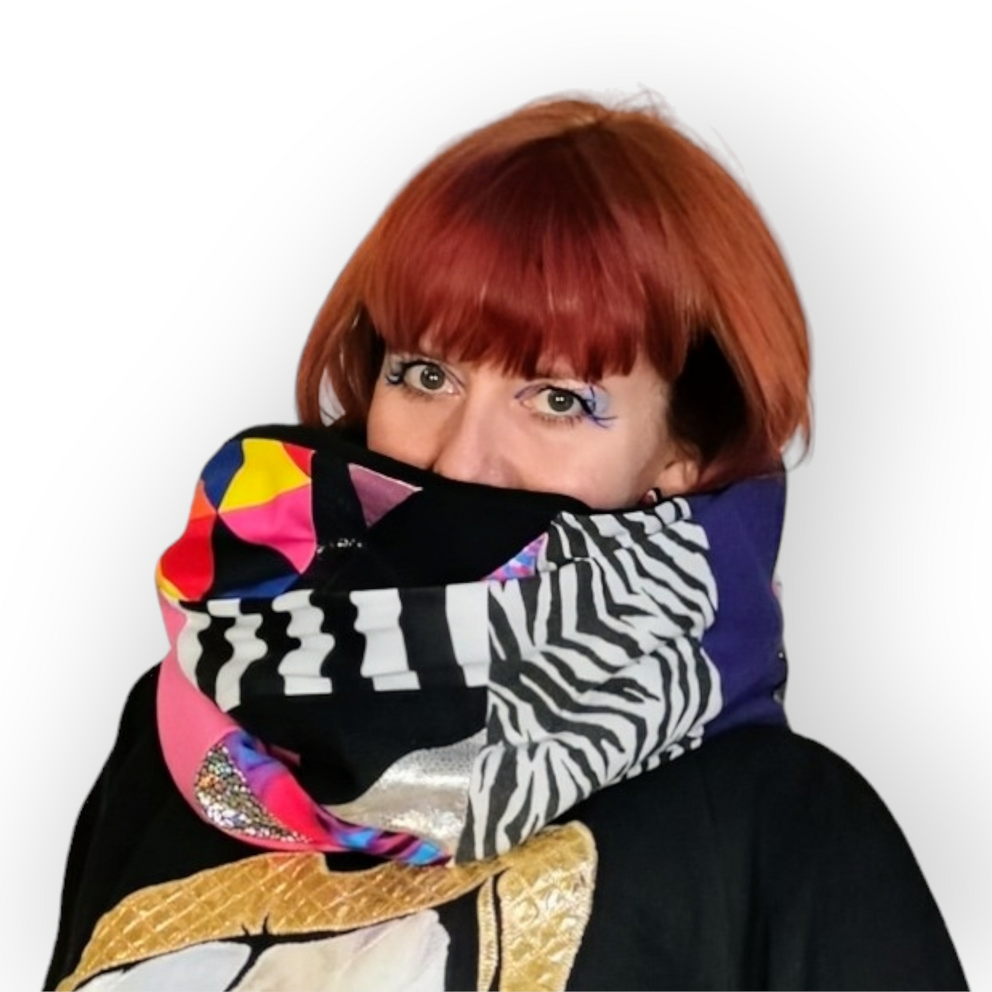 Large circular scarf made from recycled scrap fabrics.  Lined in black fleece and including bright, printed, multi coloured patchwork panels and large colour blocks in grey, pink, purple and blue. Pictured on model wrapped twice around neck. 