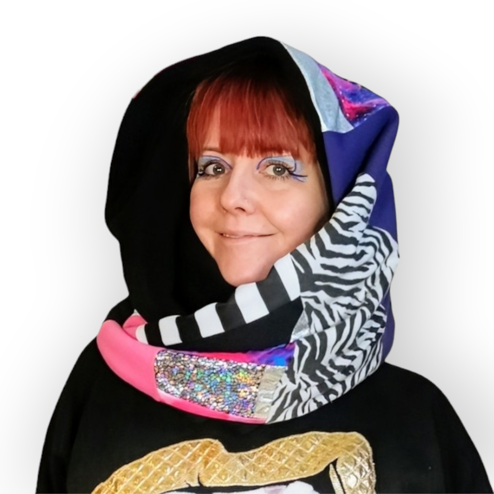 Large circular scarf made from recycled scrap fabrics.  Lined in black fleece and including bright, printed, multi coloured patchwork panels and large colour blocks in grey, pink, purple and blue. Pictured on model wrapped around neck and over head like a hood. 