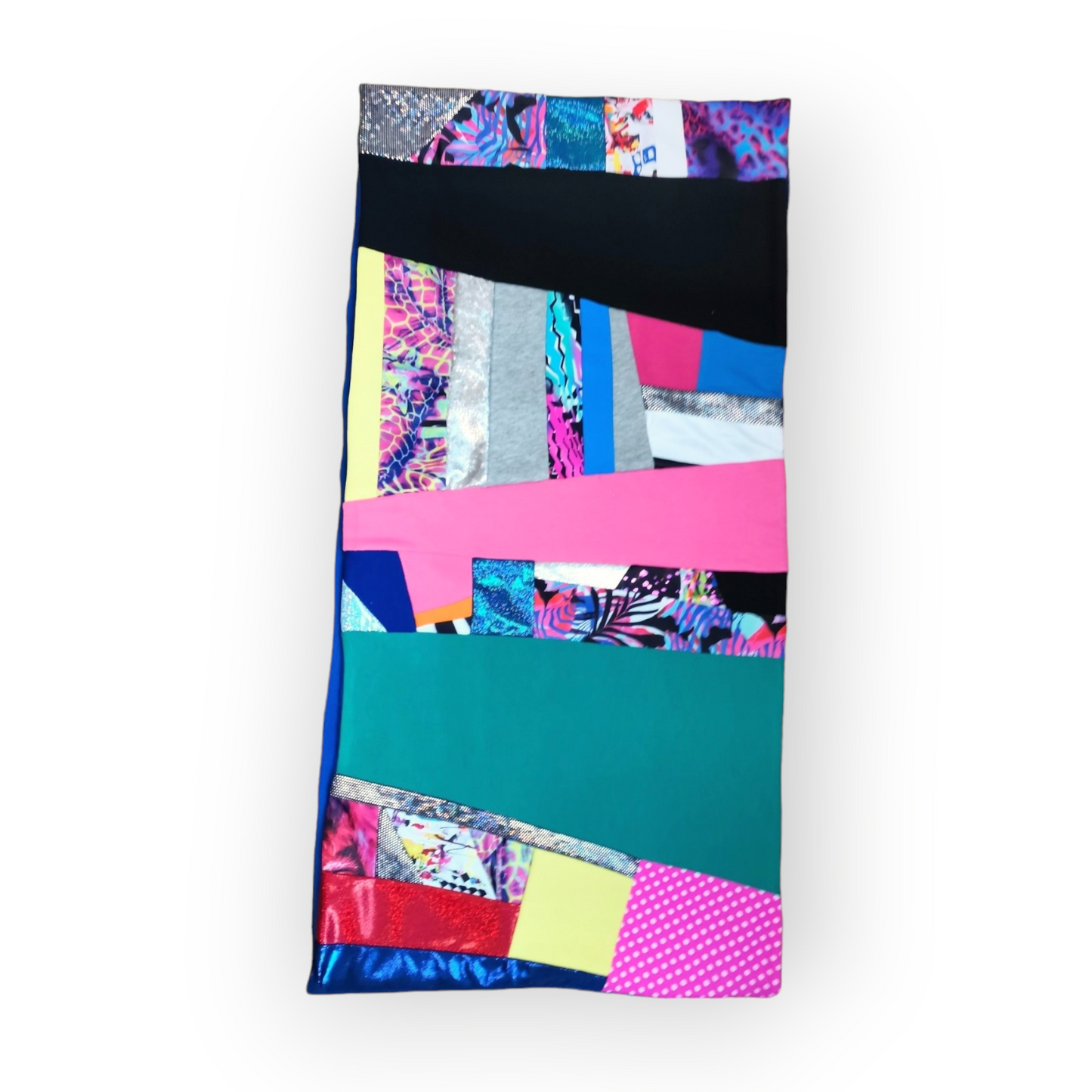 Large circular scarf made from recycled scrap fabrics.  Lined in blue fleece and including bright, printed, multi coloured patchwork panels and large colour blocks in turquoise, pink, black and blue. Pictured flat on white background. 