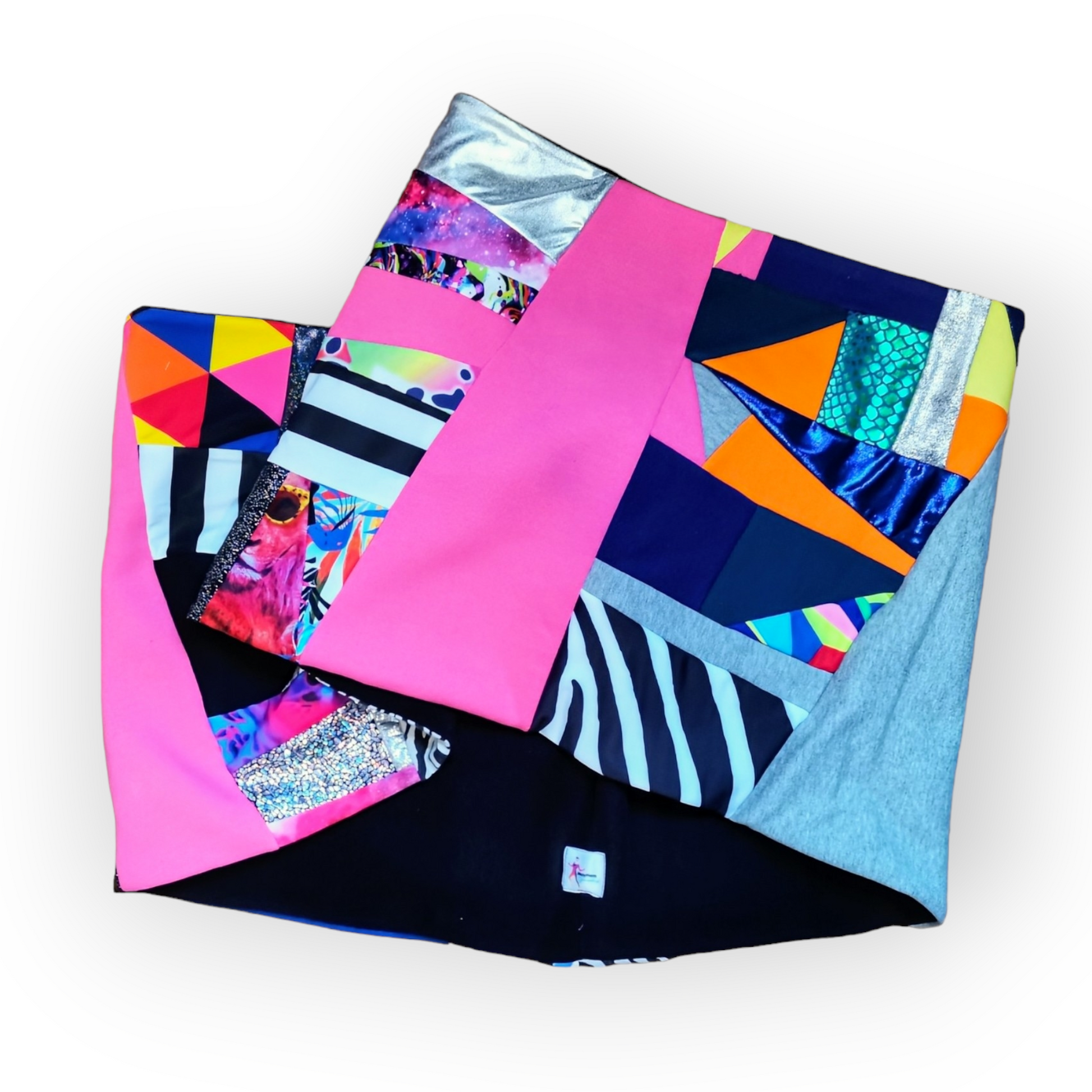 Large circular scarf made from recycled scrap fabrics.  Lined in black fleece and including bright, printed, multi coloured patchwork panels and large colour blocks in grey, pink, purple and blue. Pictured folded to show outer and lining on white background. 