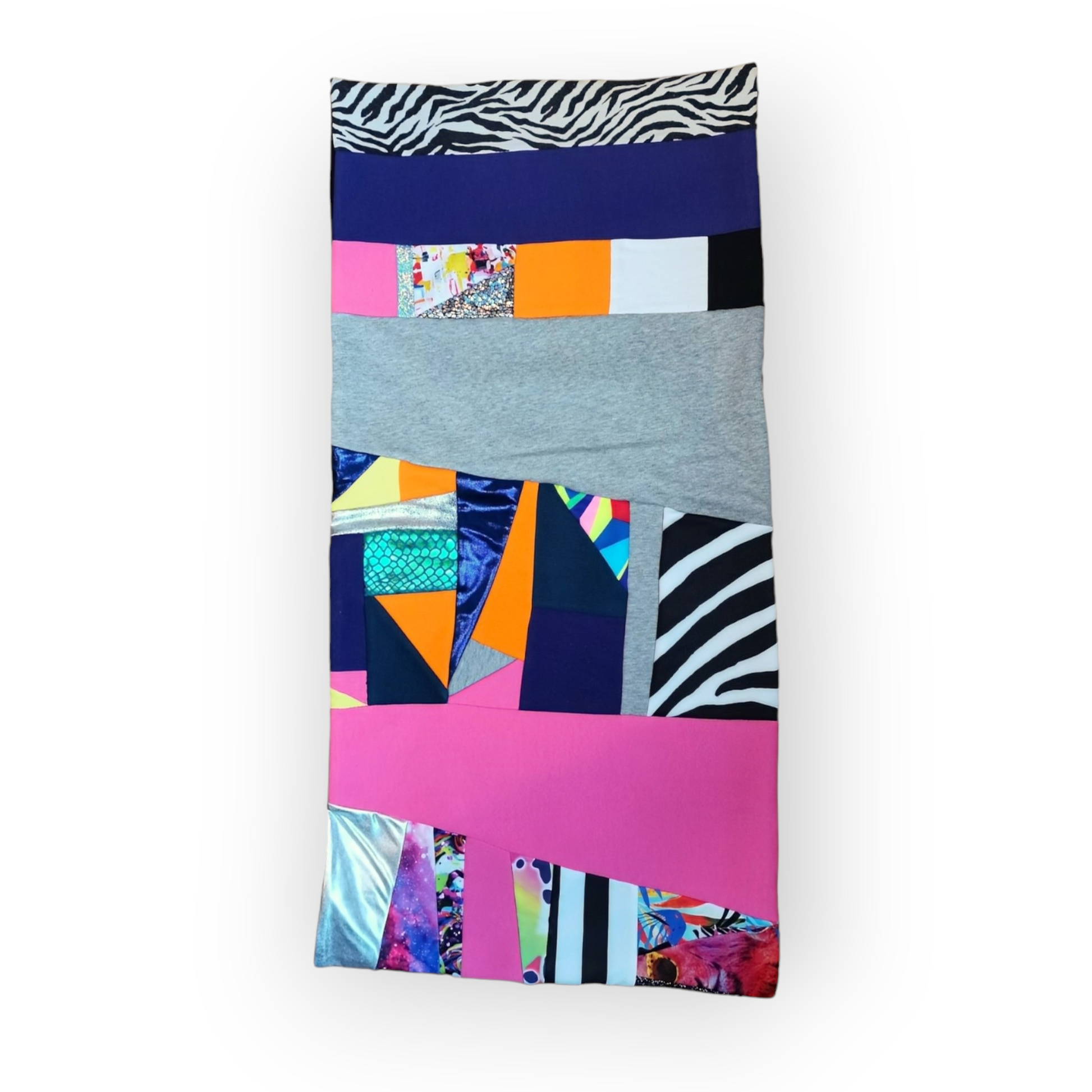 Large circular scarf made from recycled scrap fabrics.  Lined in black fleece and including bright, printed, multi coloured patchwork panels and large colour blocks in grey, pink, purple and blue. Pictured flat on white background. 