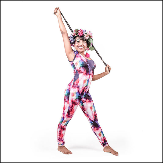 Supernova Catsuit, a handmade-to-order piece in galactic pink printed spandex. This statement catsuit is both stylish and sustainable. The unisex design features a flattering V-neck with a black mesh insert and curved black mesh side panels that hug your curves in all the right places.