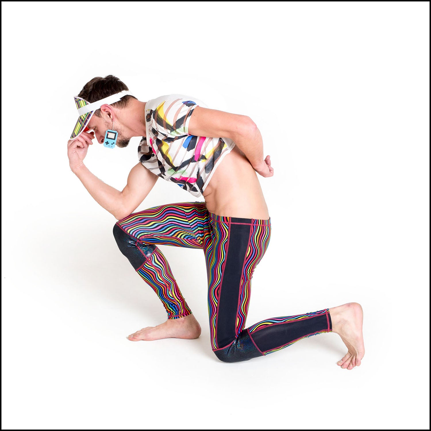 Twisted Leggings, a handmade-to-order piece in rainbow groovy stripe printed spandex. These funky leggings are both stylish and sustainable. The unisex design features a high elasticated waistband and black hologram knee and side panels.