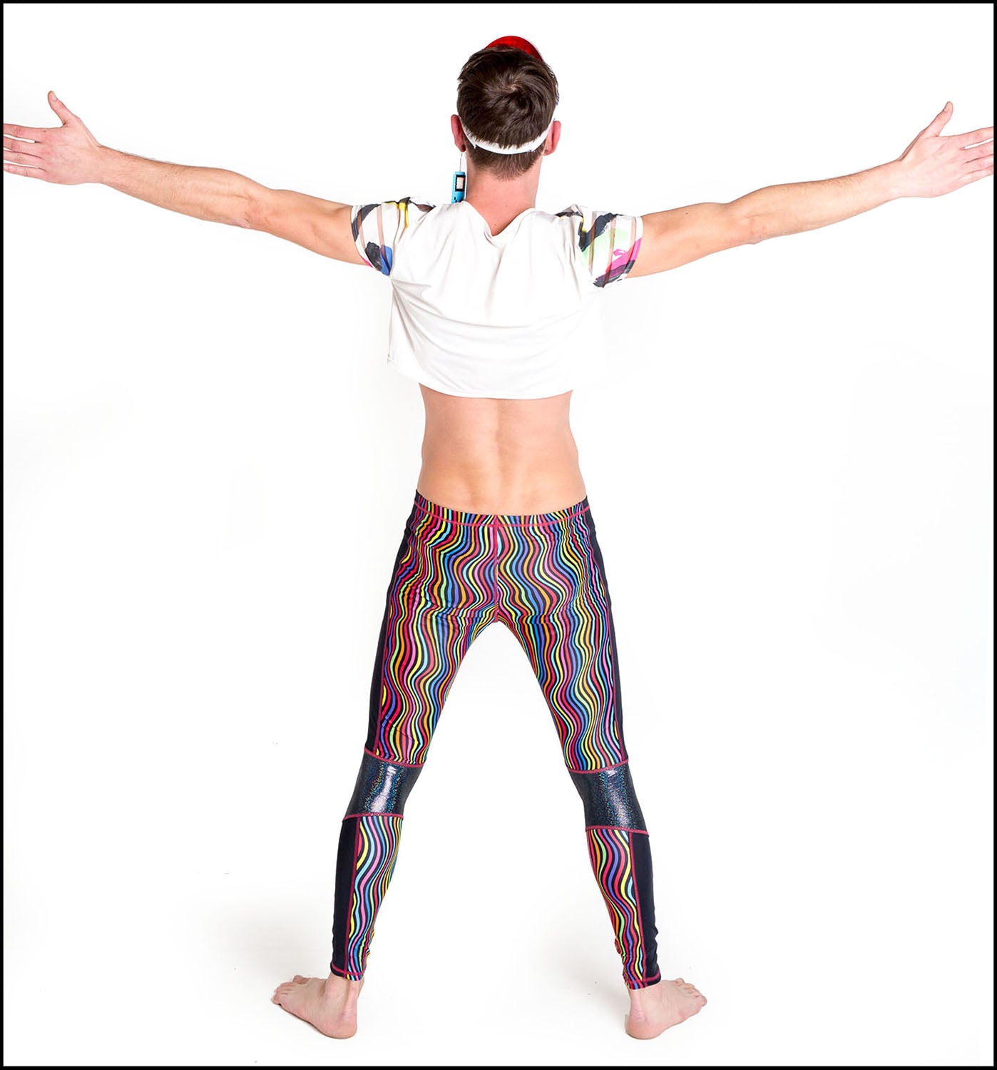 Twisted Leggings, a handmade-to-order piece in rainbow groovy stripe printed spandex. These funky leggings are both stylish and sustainable. The unisex design features a high elasticated waistband and black hologram knee and side panels.
