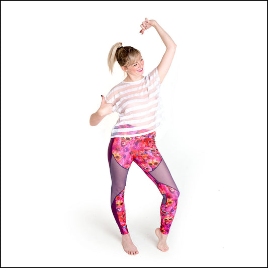 Cool Cat Leggings, a handmade-to-order piece in pink lion fest printed spandex. These super cool leggings are both stylish and sustainable. The unisex design features a high double waistband, purple mesh knee panels and pink hologram foil side panels.