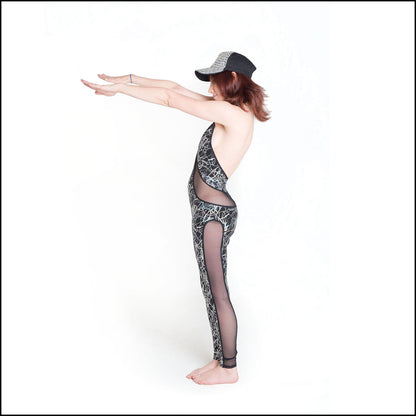 Tangle Lazer Catsuit, a handmade-to-order piece in foil printed tangle lazer spandex. This sexy, low back catsuit is both stylish and sustainable. The figure hugging design features a high halter neck and flattering black mesh inserts that hug your curves in all the right places.