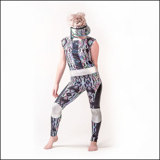 Serpens Catsuit, a handmade-to-order piece in rainbow snakeskin printed spandex. This funky high neck catsuit is both stylish and sustainable. The unisex design features a high round neck, black hologram inserts and silver liquid foil neck, waist and knee panels. 